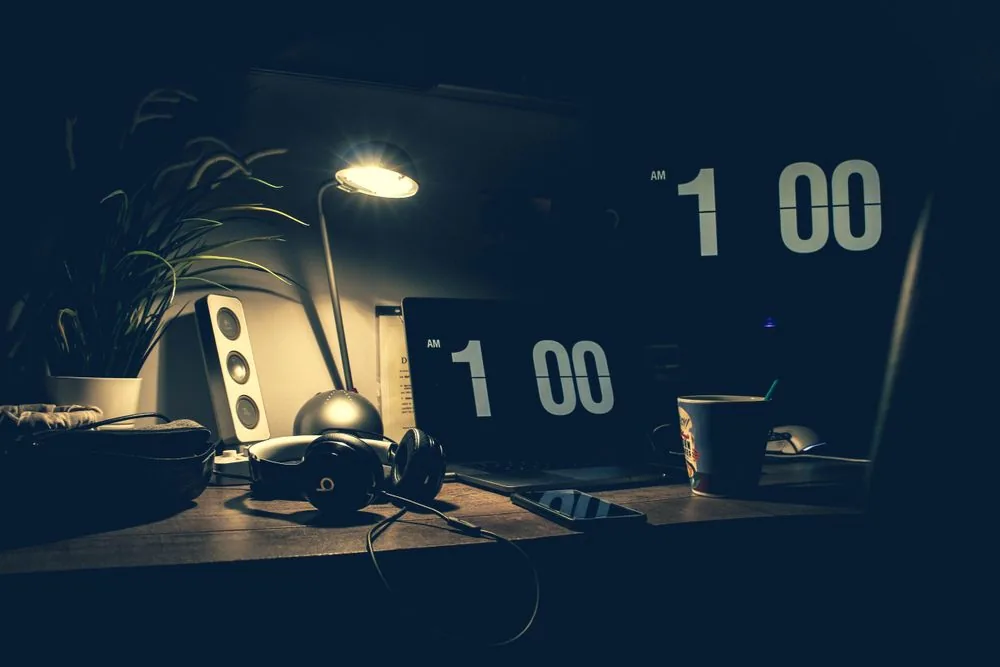 A dimly lit office desk late in the evening